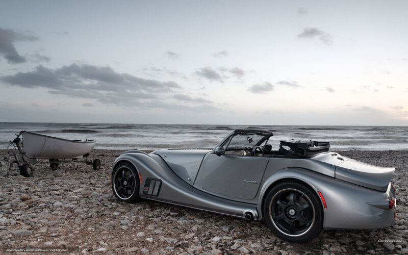 Silver sports car on a pebble beach