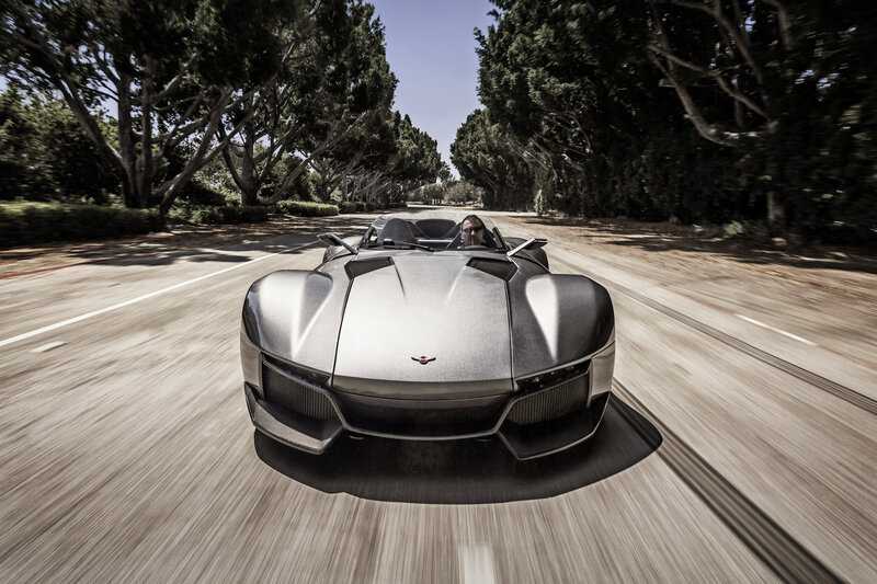 Silver sports car on a tree-lined road