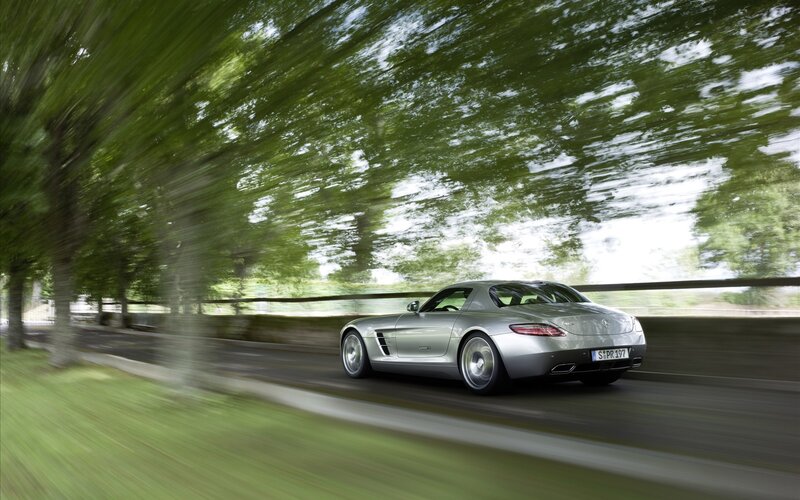 Silver sports car on a tree-lined road