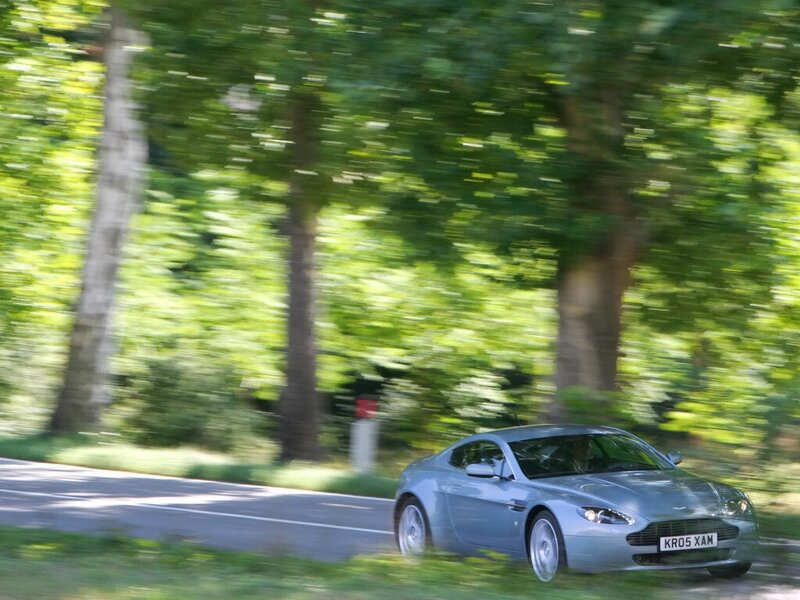 Silver sports car on a tree-lined road