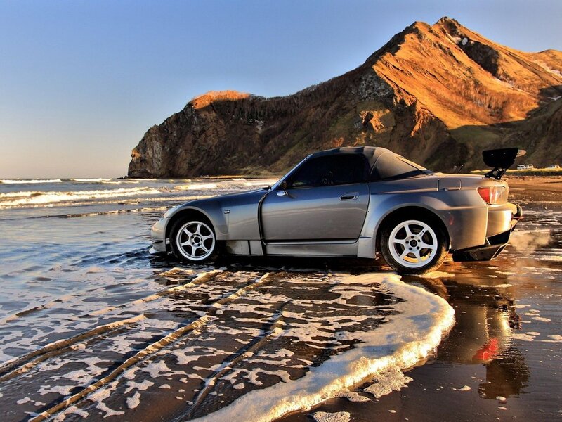 Silver sports car on beach