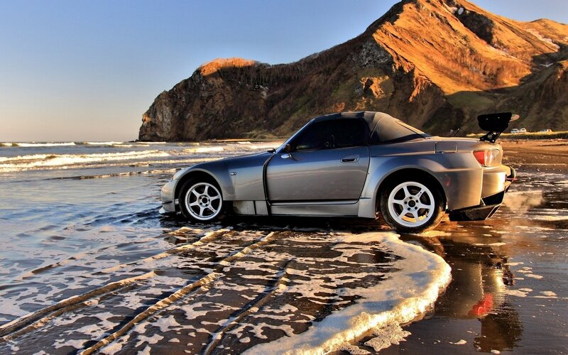 Silver sports car on beach