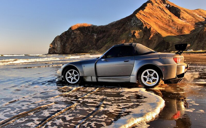 Silver sports car on beach