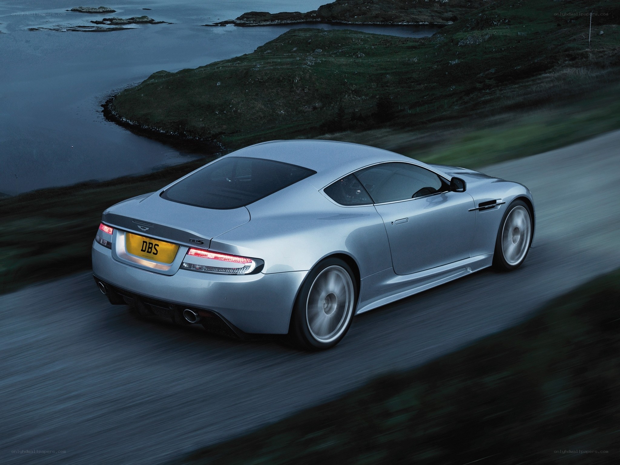 silver sports car on coastal road