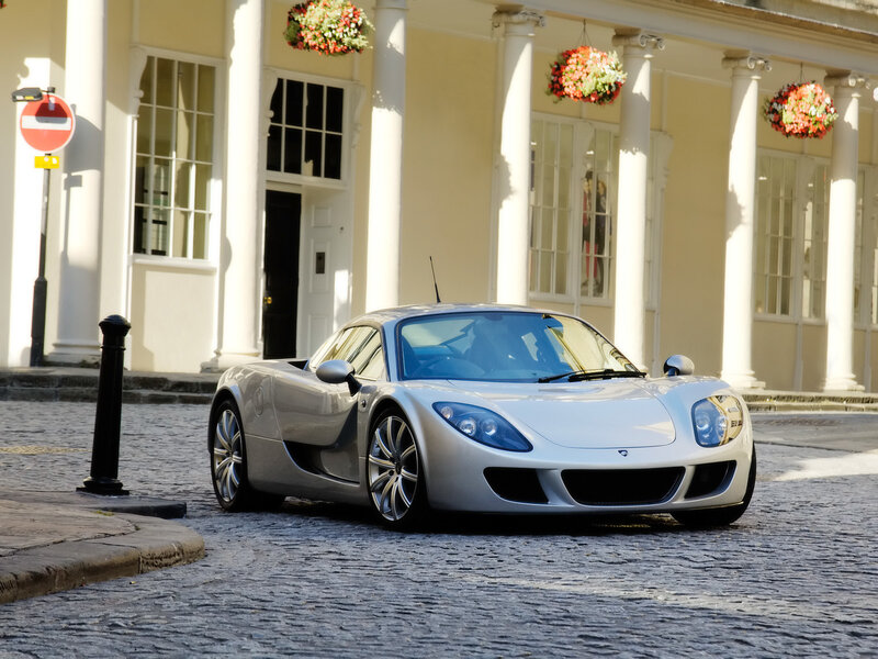 silver sports car on cobblestone street