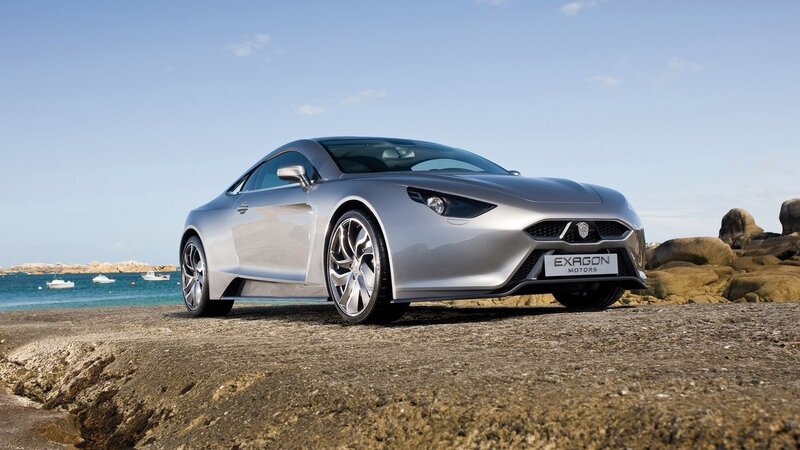 Silver sports car on rocky shore