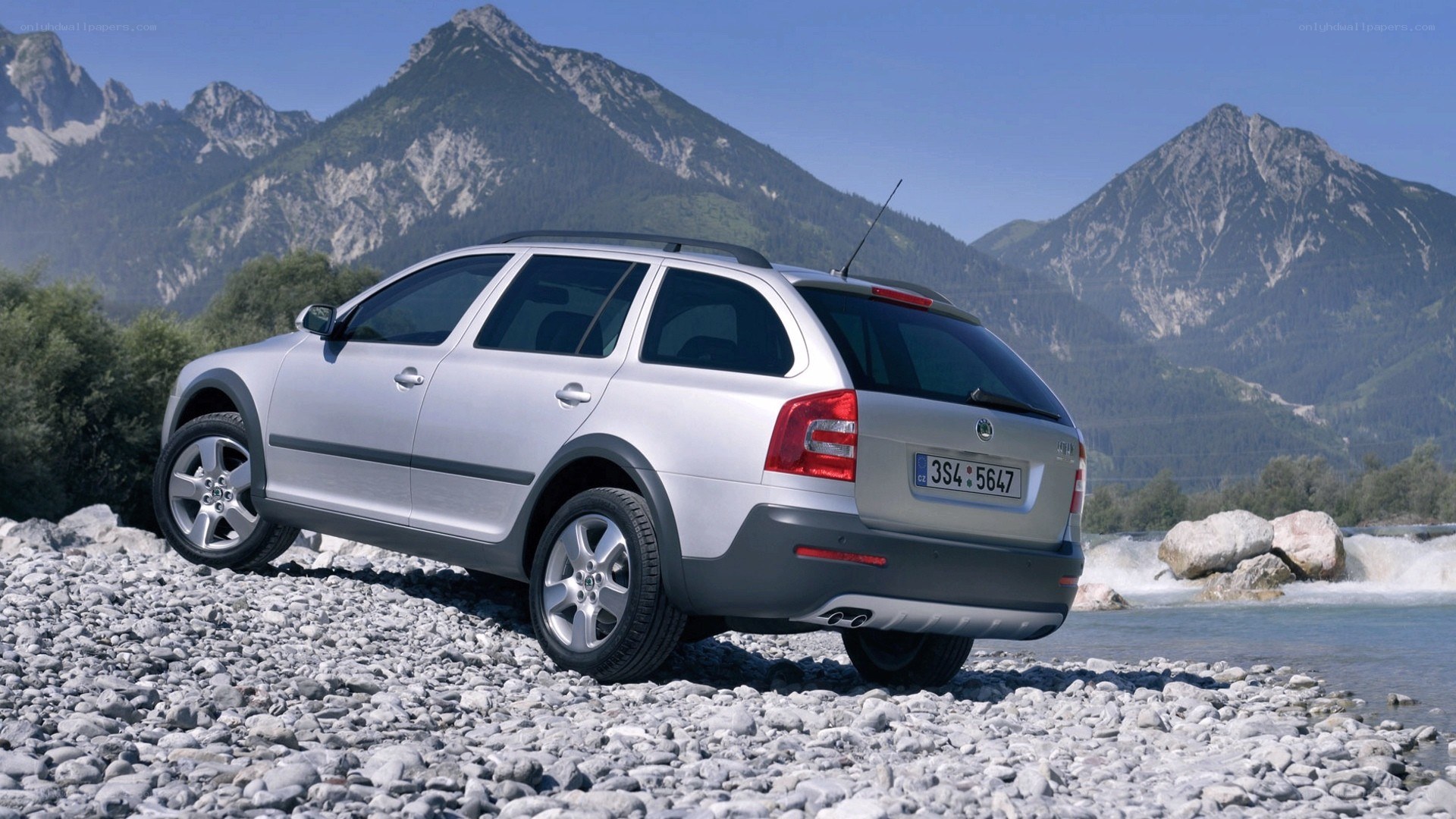 Silver station wagon on riverbank