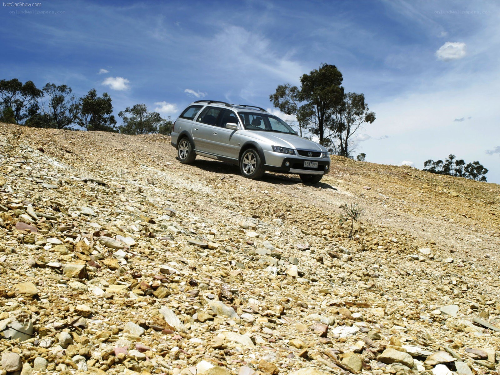 Silver station wagon on rocky hill
