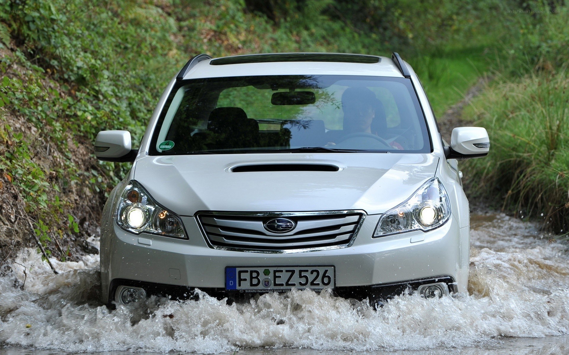 Silver Subaru driving through water