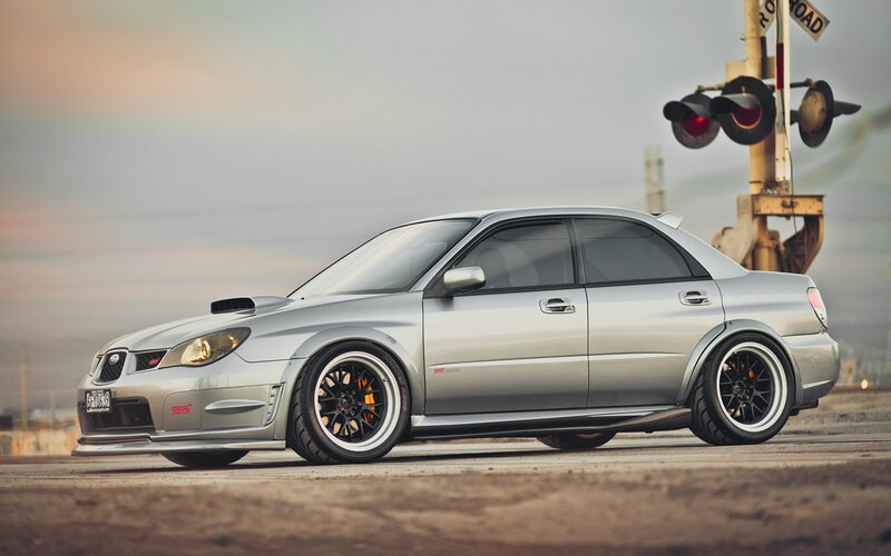 silver subaru wrx sti at railroad crossing