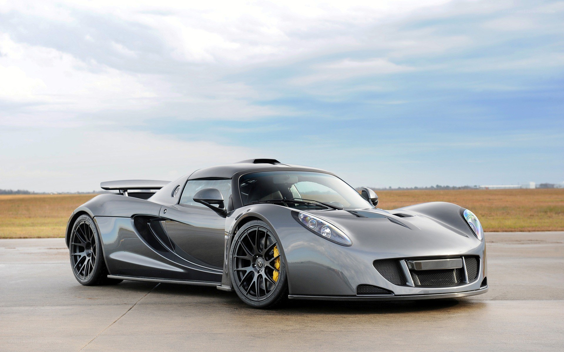 silver supercar on tarmac
