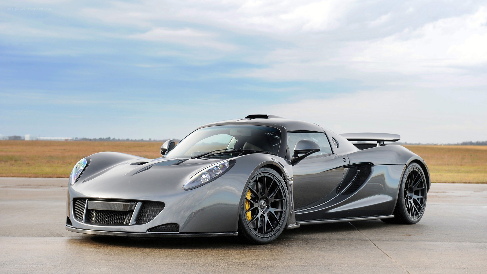 silver supercar on tarmac