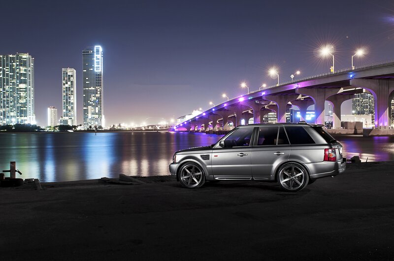 Silver SUV at night by the bridge