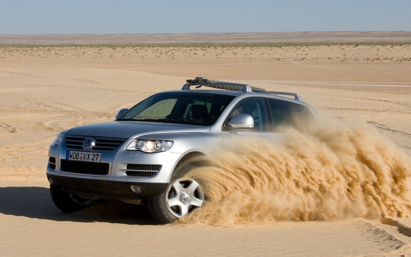 Silver SUV driving in desert