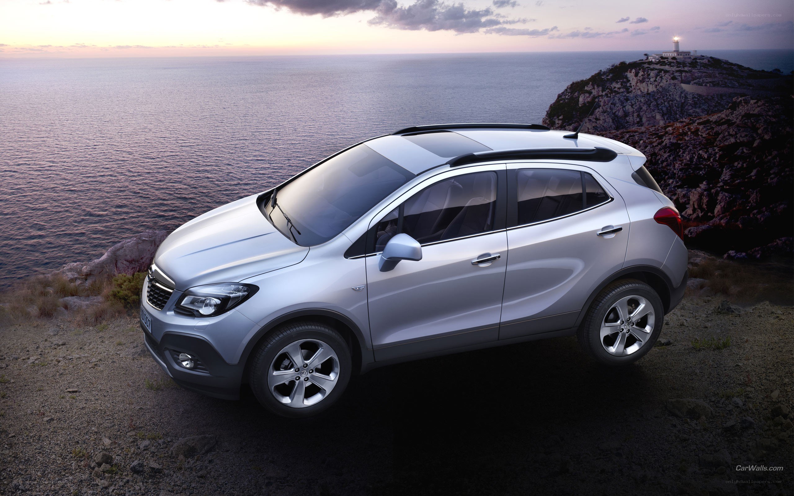 Silver SUV on cliffside at sunset