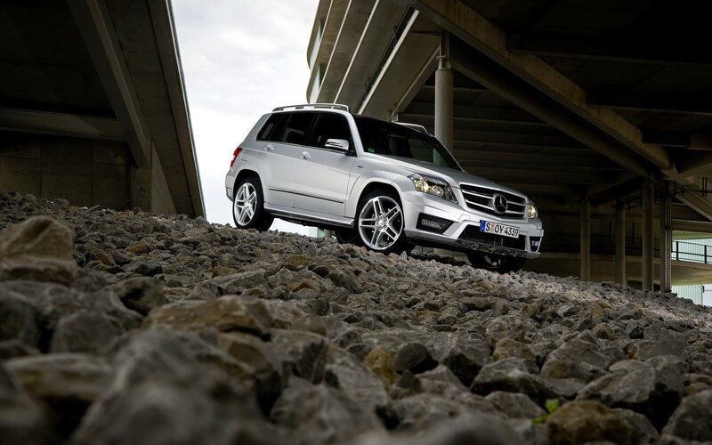 Silver SUV on gravel under bridge