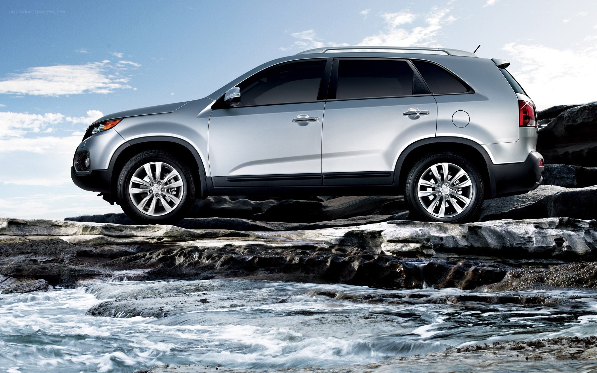 Silver SUV on rocky shore