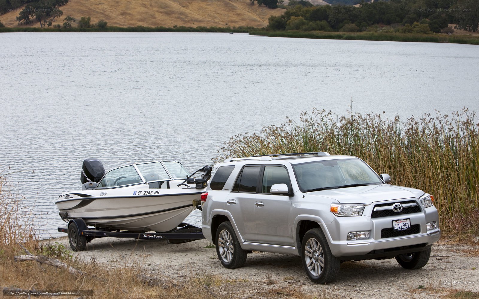 Silver SUV towing boat at lake