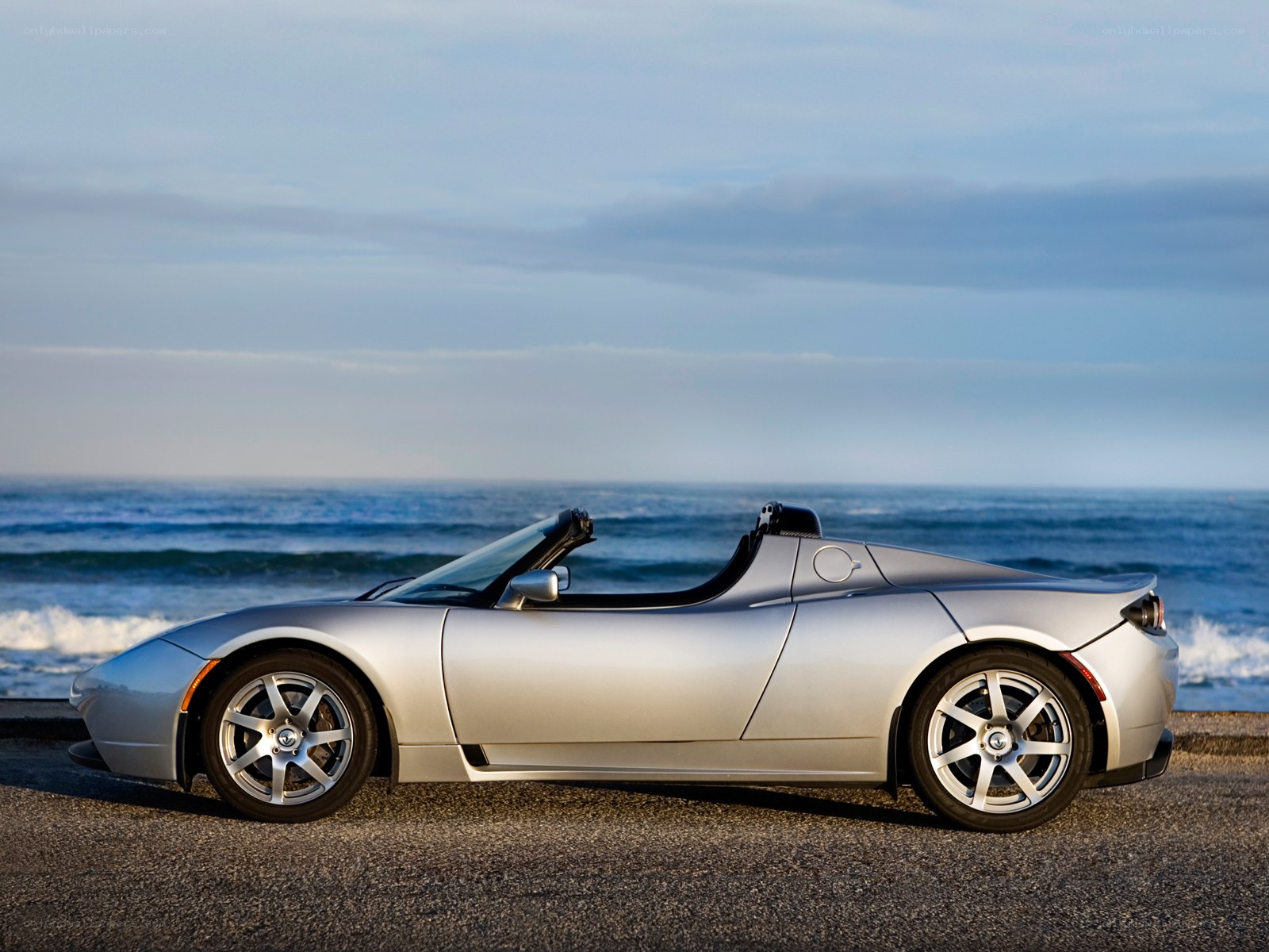 Silver Tesla Roadster by the ocean