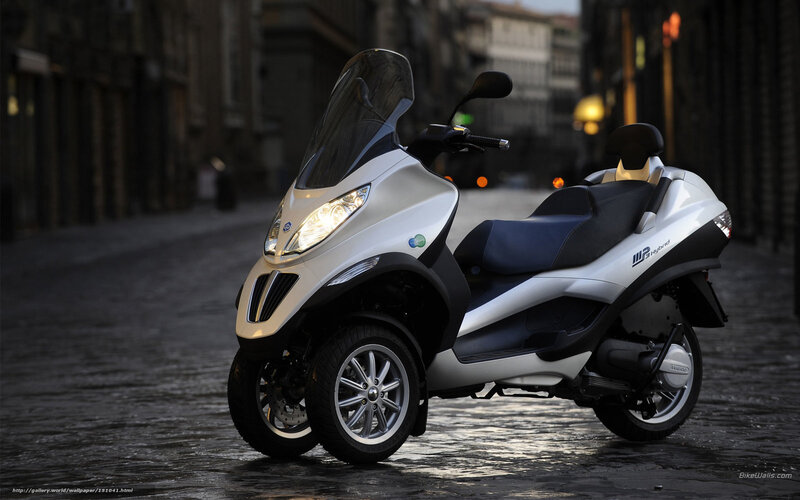 Silver three-wheeled scooter on street