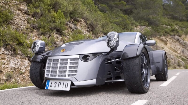 Silver three-wheeled sports car on road