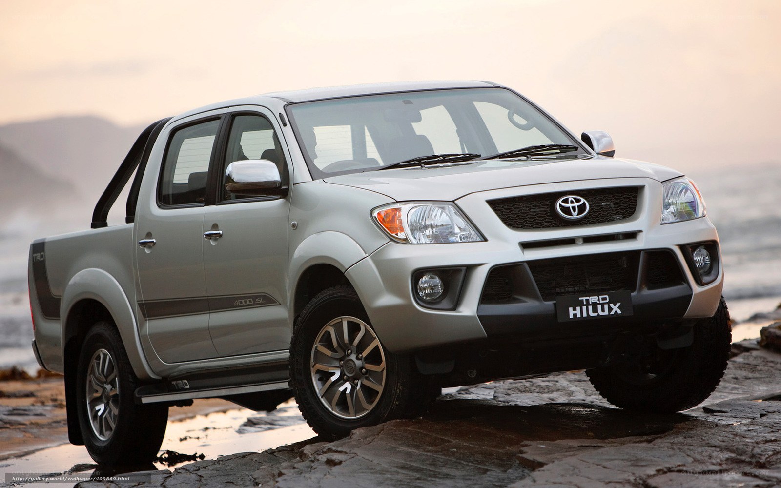 Silver Toyota Hilux on rocky shore