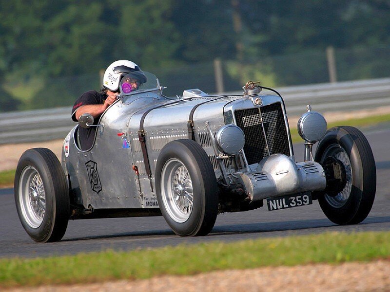 Silver vintage race car on track