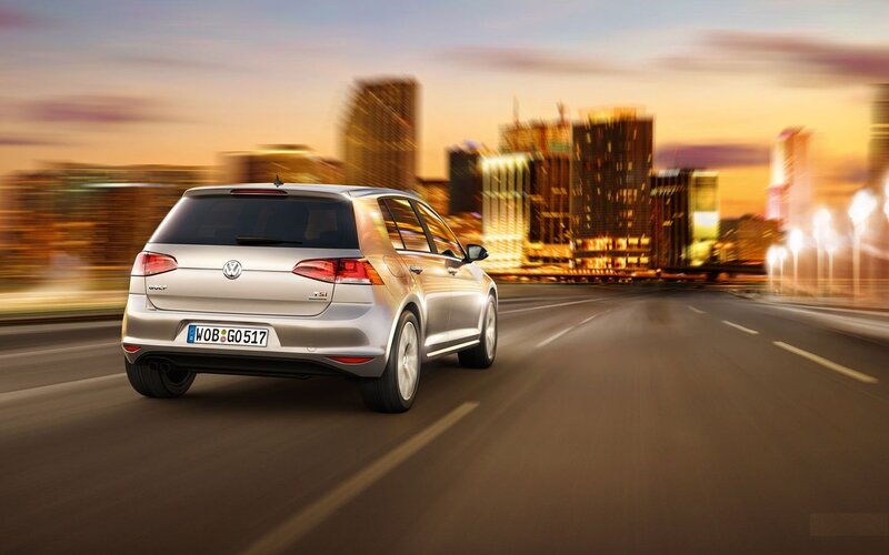 Silver Volkswagen Golf driving at dusk