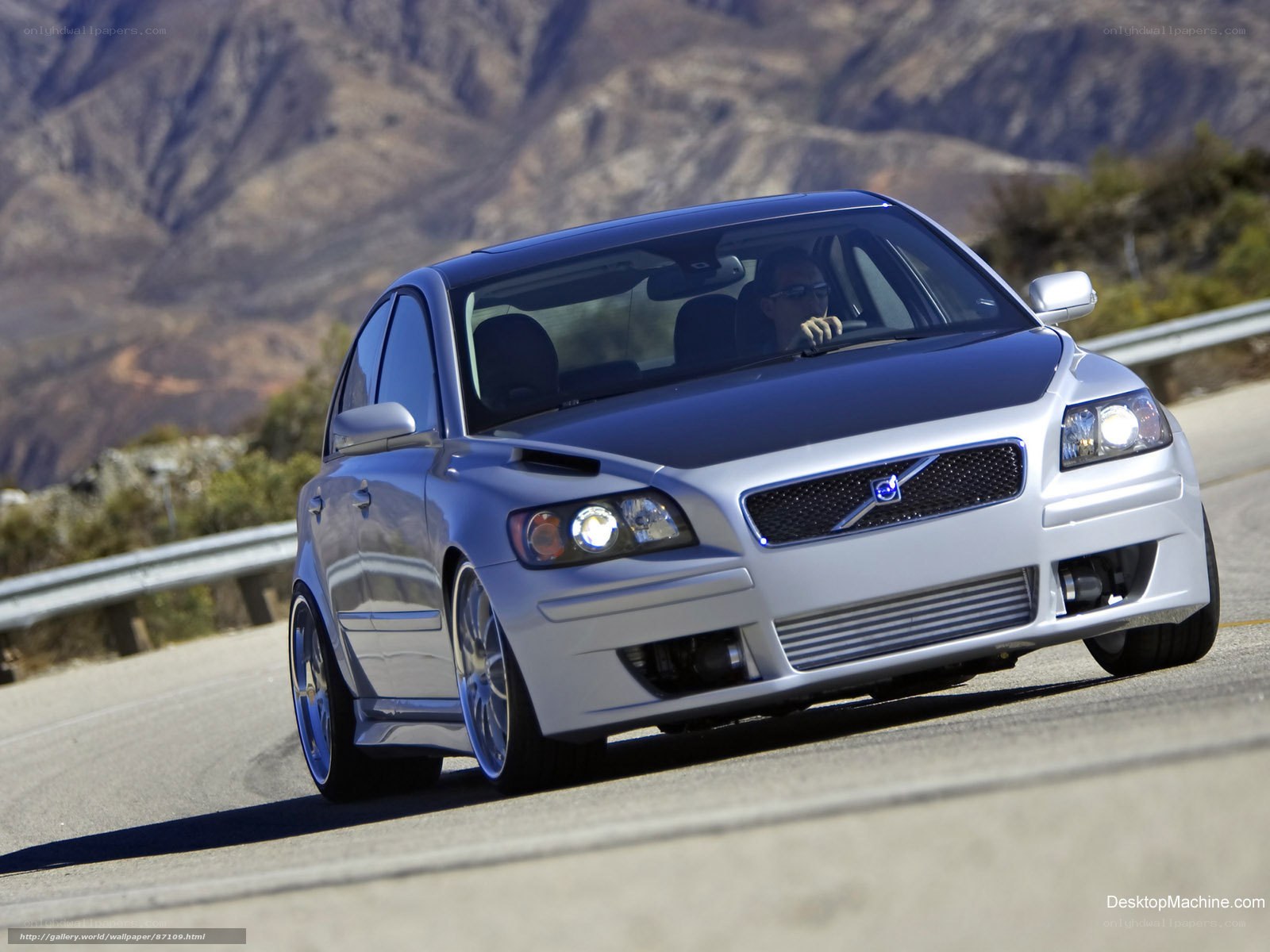 silver volvo driving on mountain road