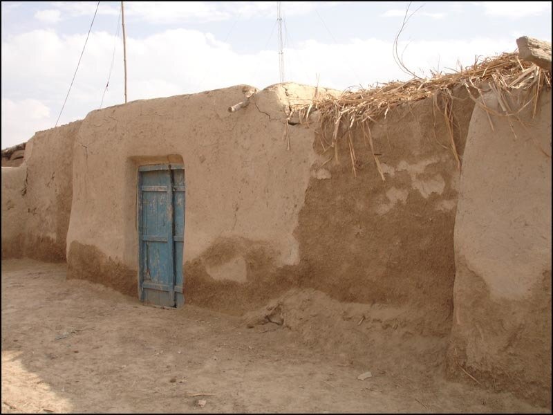 simple mud hut with blue door