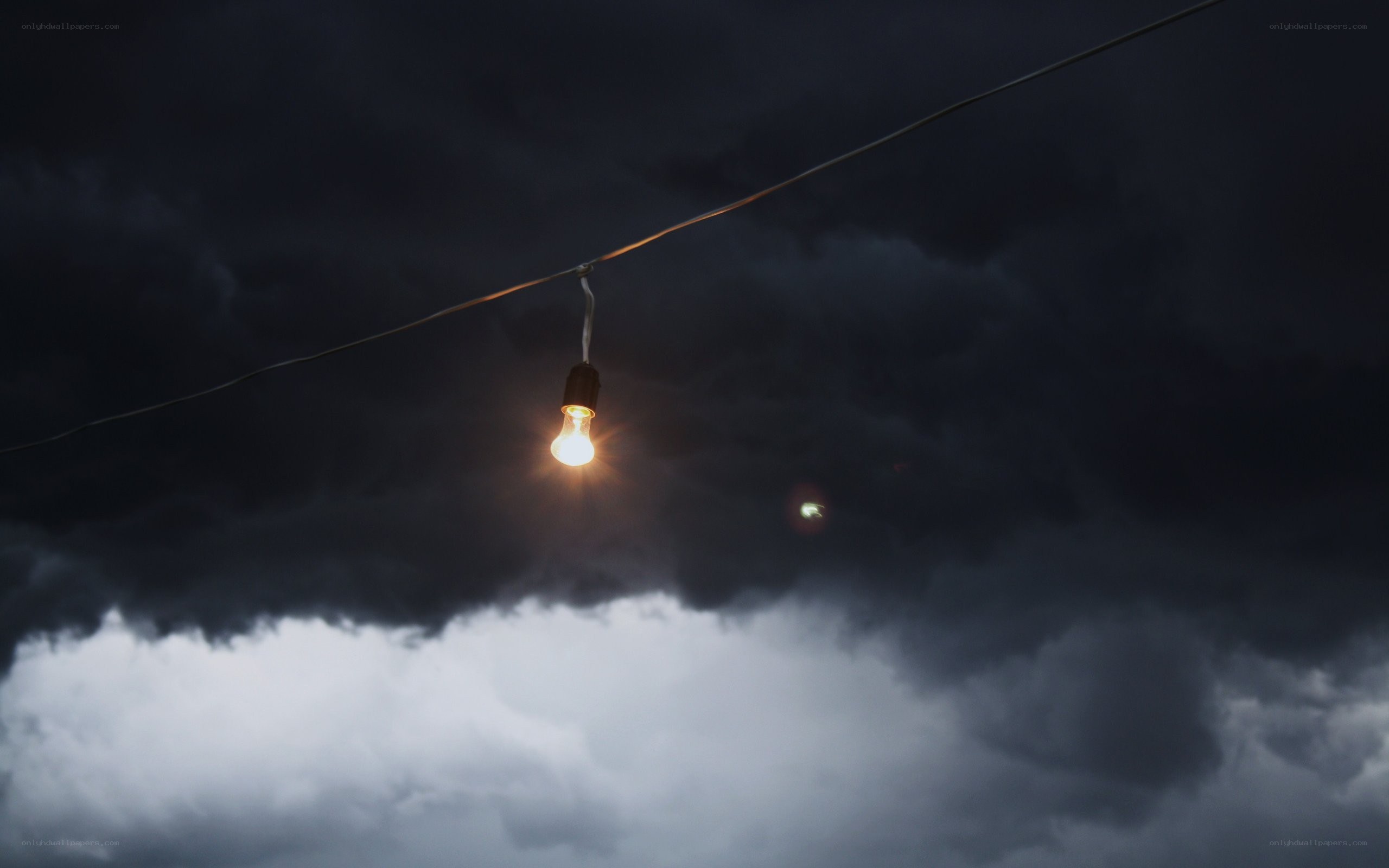 single light bulb in stormy sky