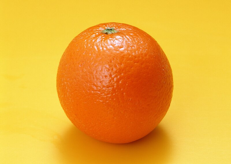 single orange on yellow