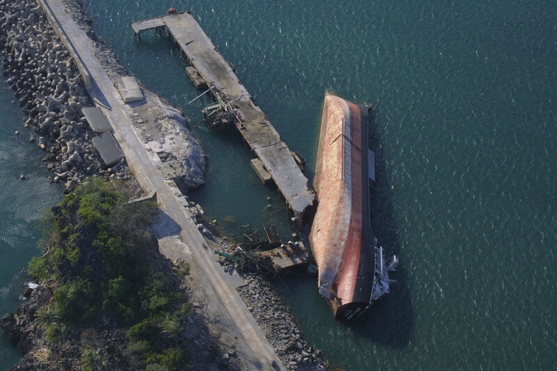 Sinking ship at a damaged pier
