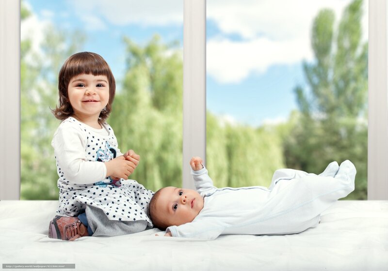 sister and baby on bed