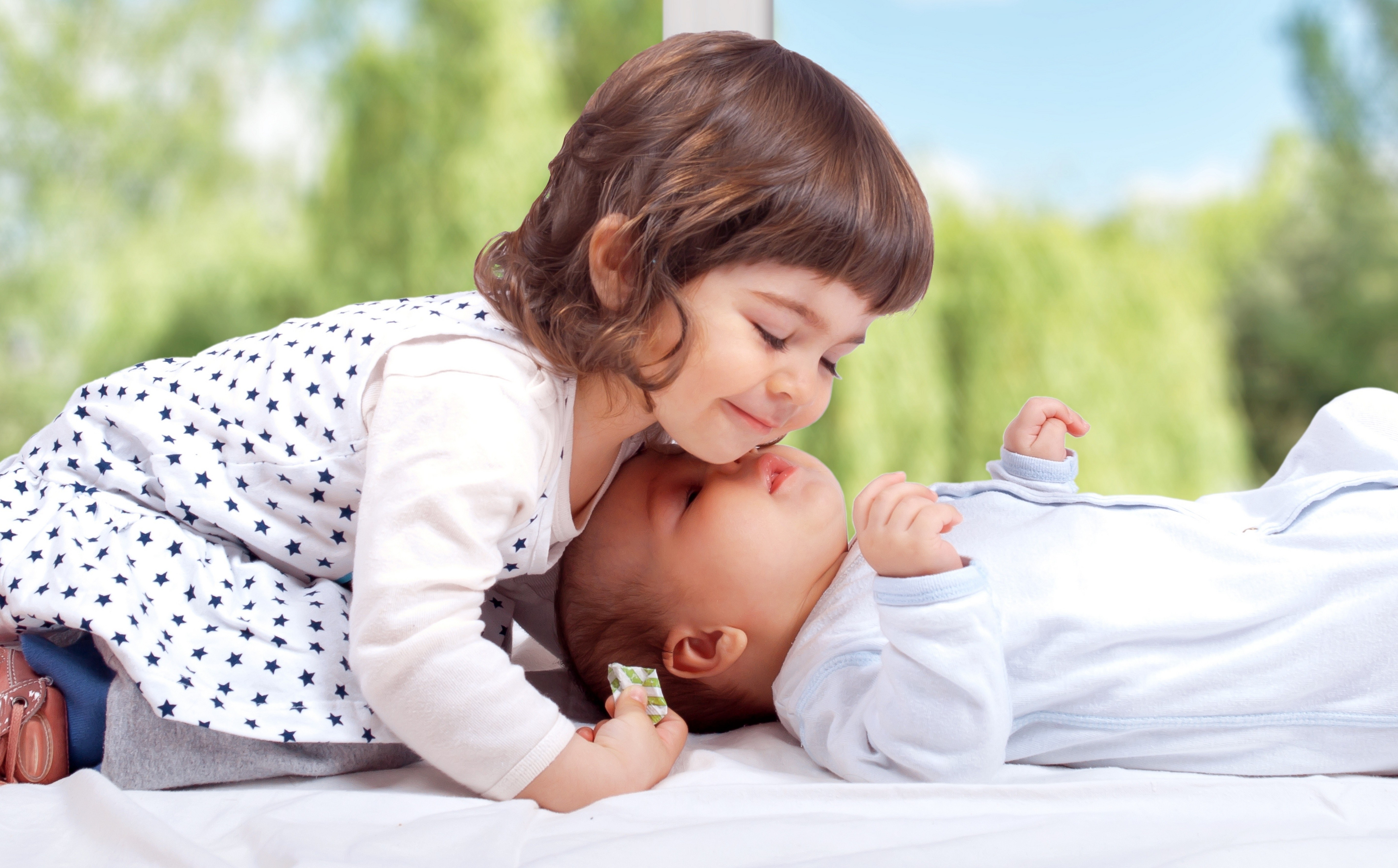 sister kissing baby sibling