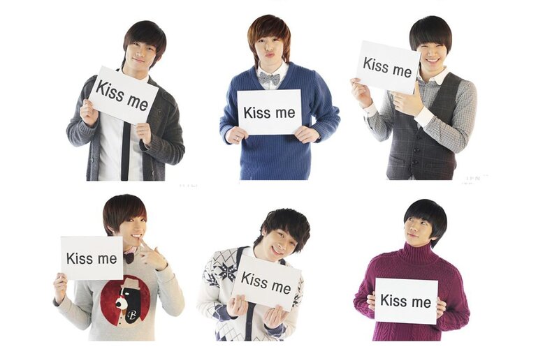 Six men holding 'Kiss me' signs