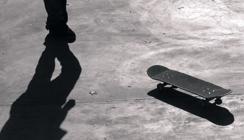 Skateboard and shadow on pavement