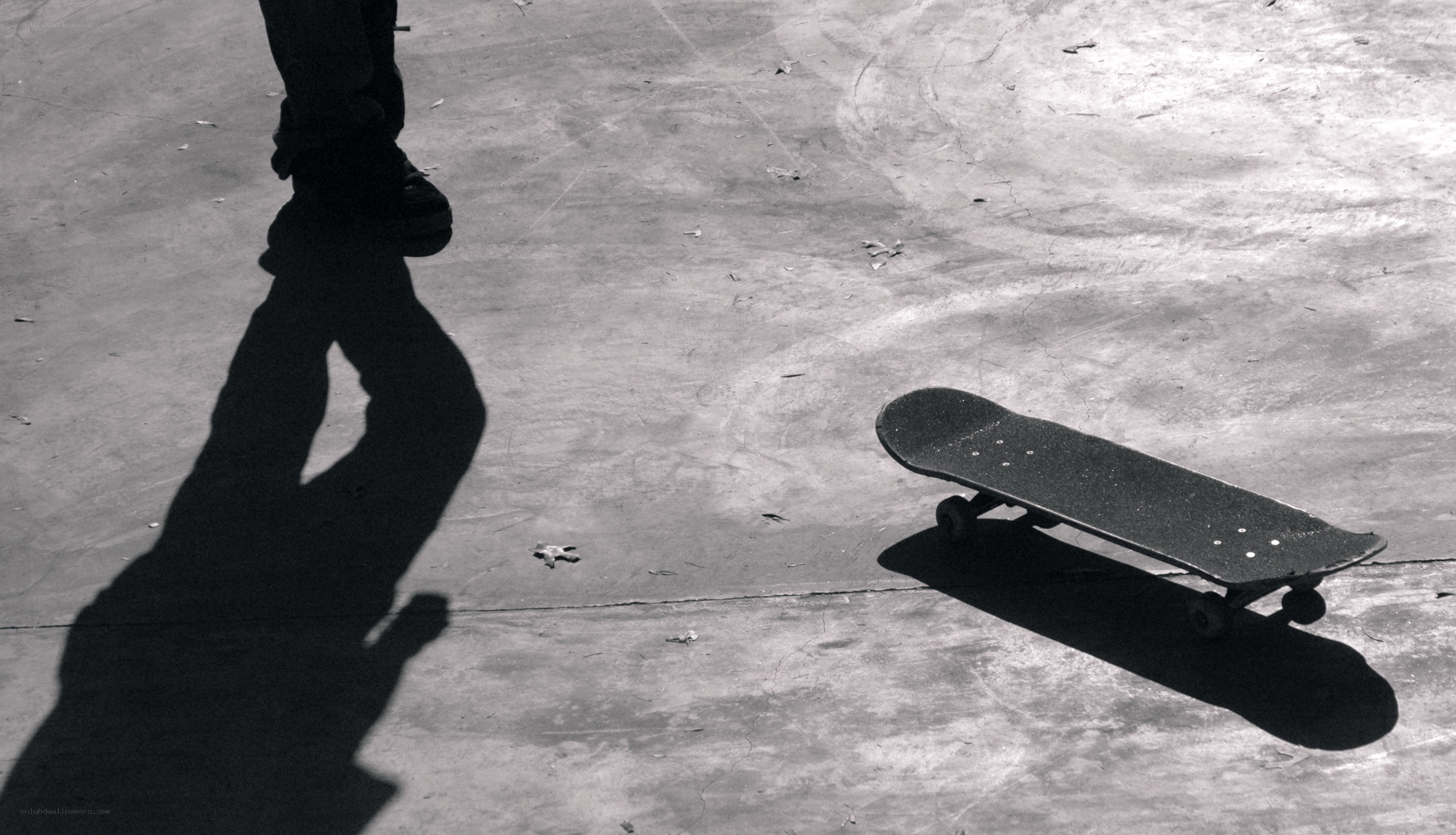 Skateboard and shadow on pavement