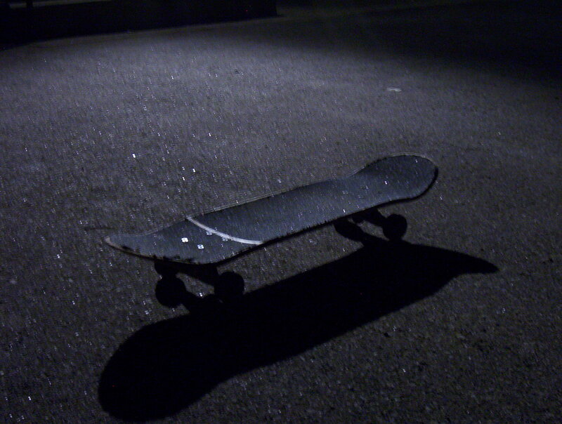 skateboard on pavement at night