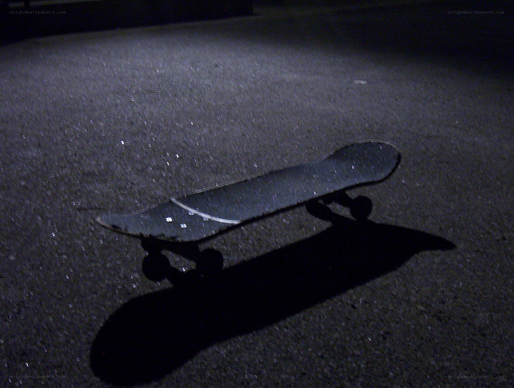 skateboard on pavement at night