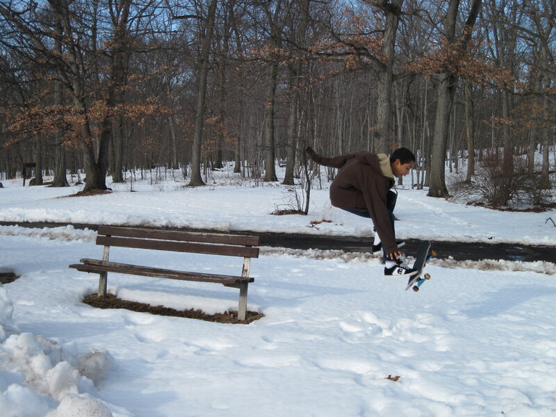 Skateboarder in snowy park