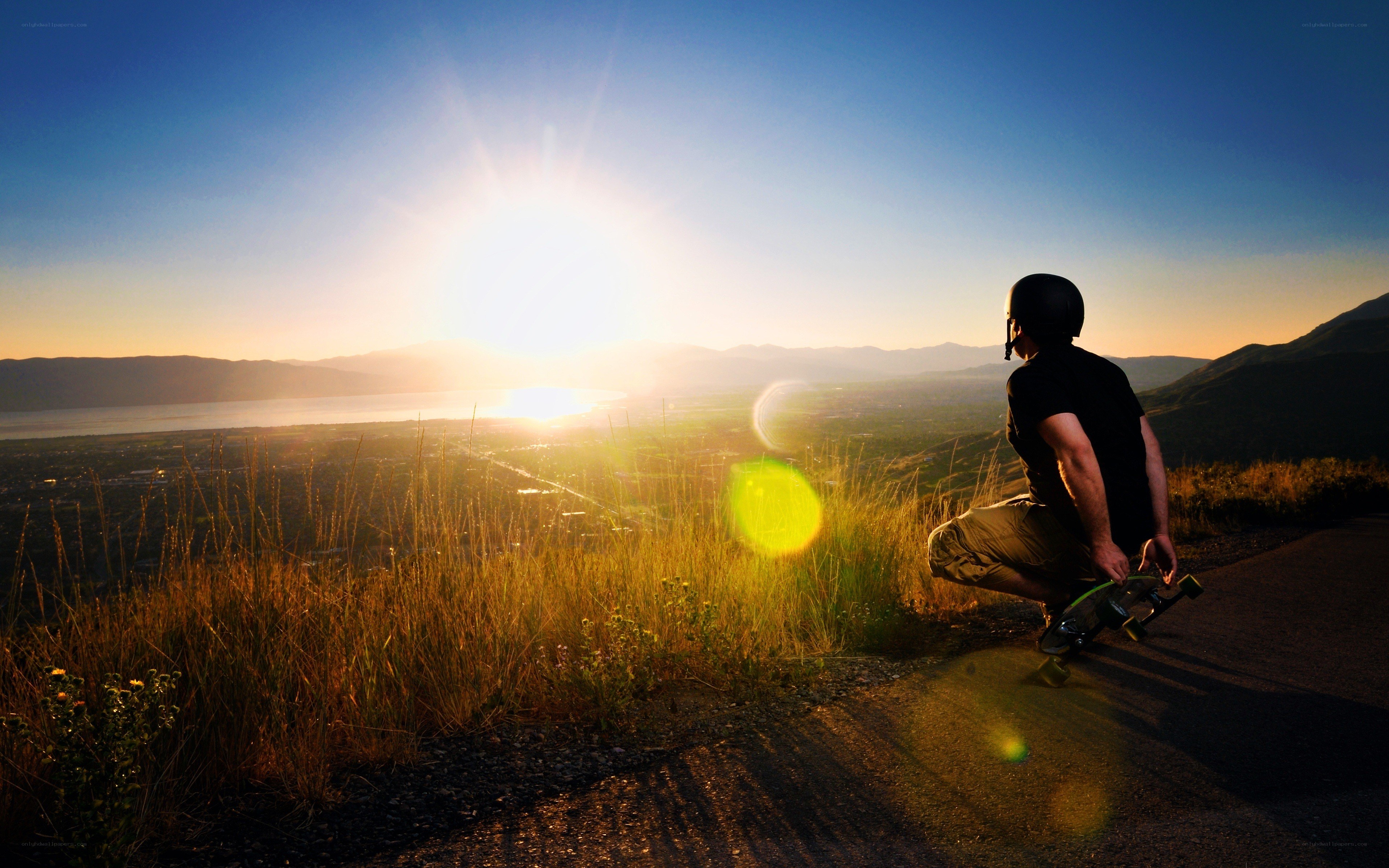 Skater at sunset overlooking a valley