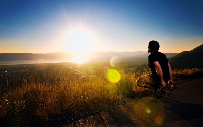 Skater at sunset overlooking a valley