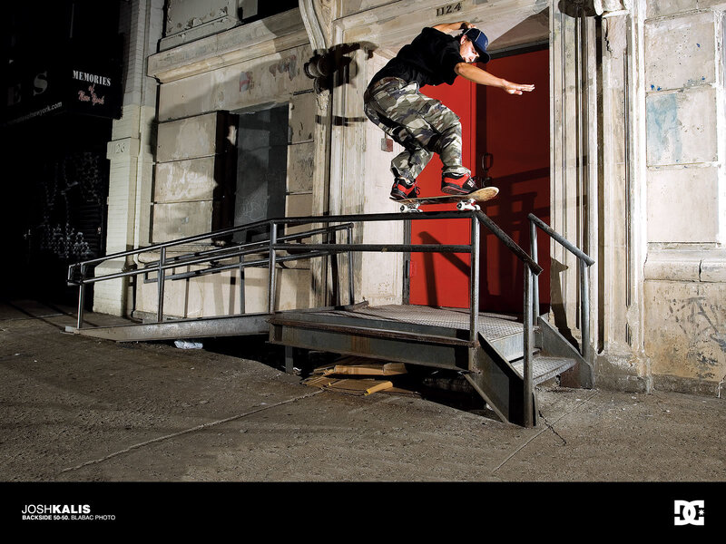 Skater grinding rail at night