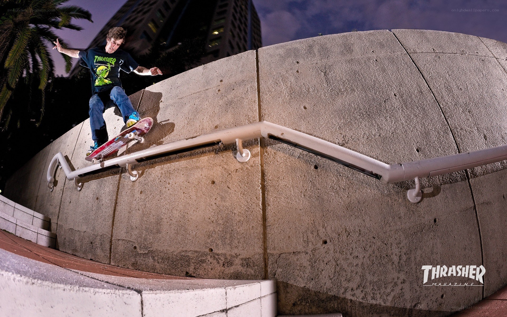 skater grinding rail at night