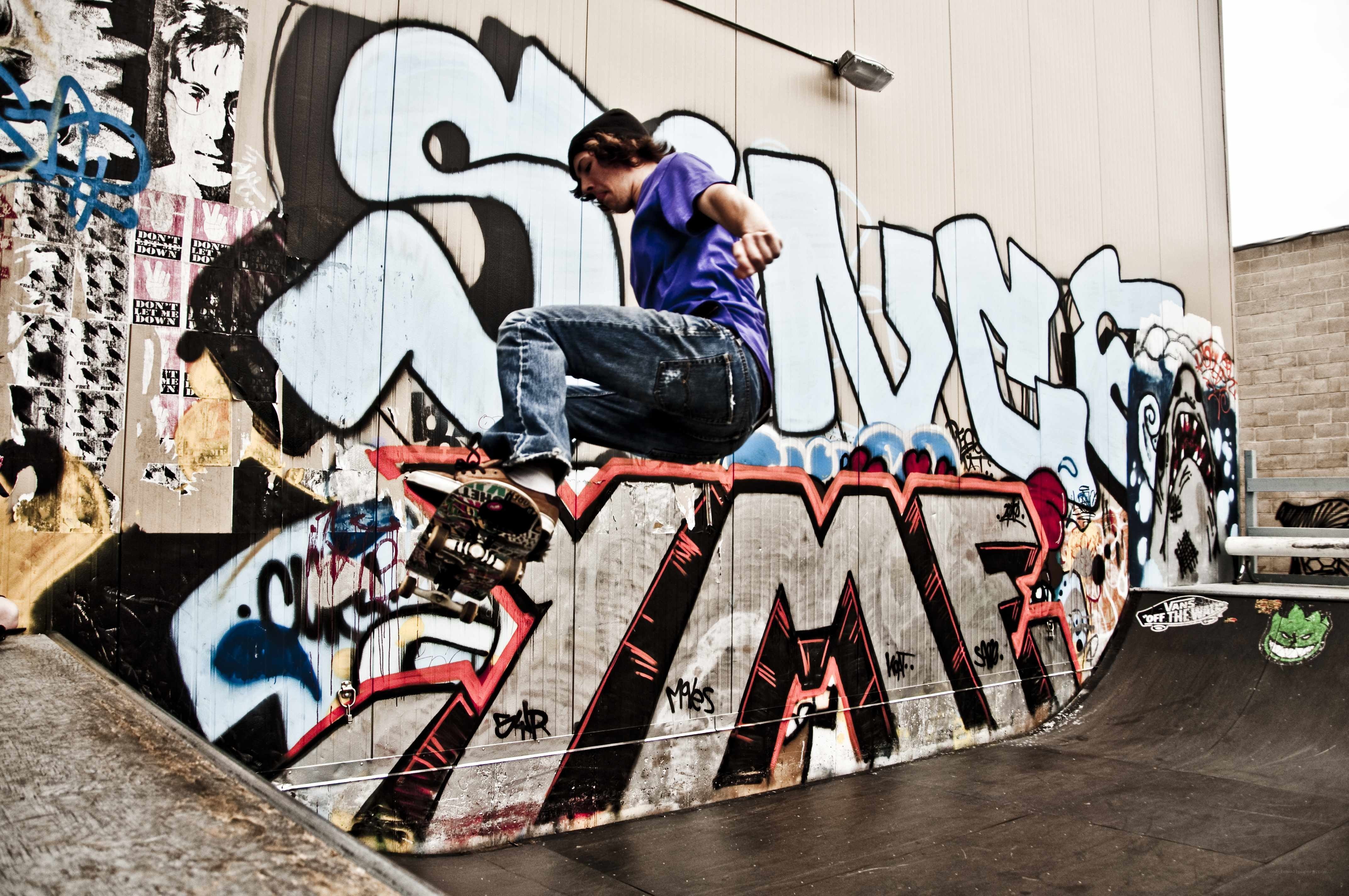 Skater on graffiti wall