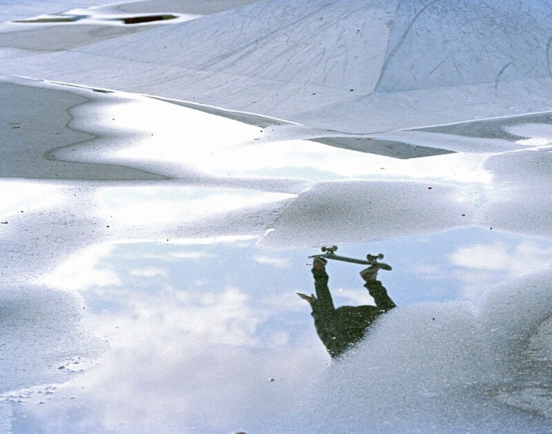 Skater's reflection in a puddle