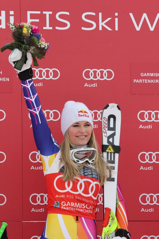 Ski racer on podium with flowers
