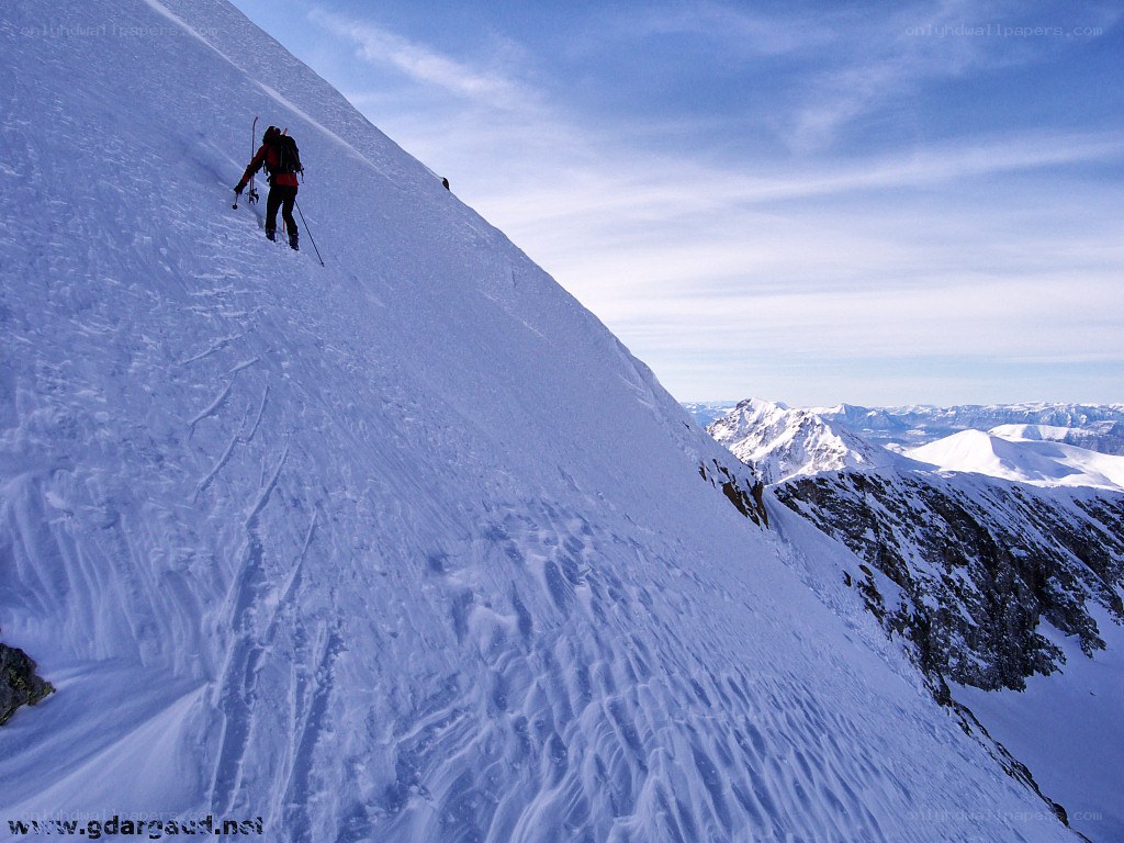 Skier ascending snowy mountain