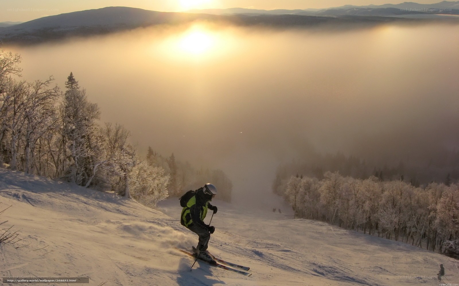 Skier at sunset in snowy mountains